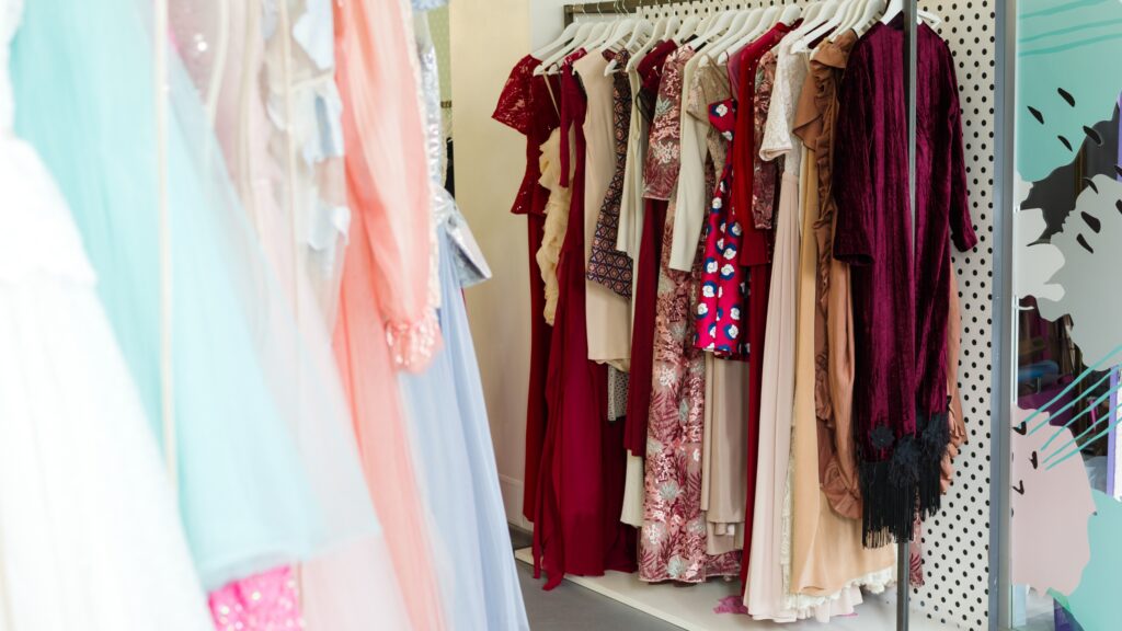 Rack filled with elegant and colorful wedding guest dresses for summer.